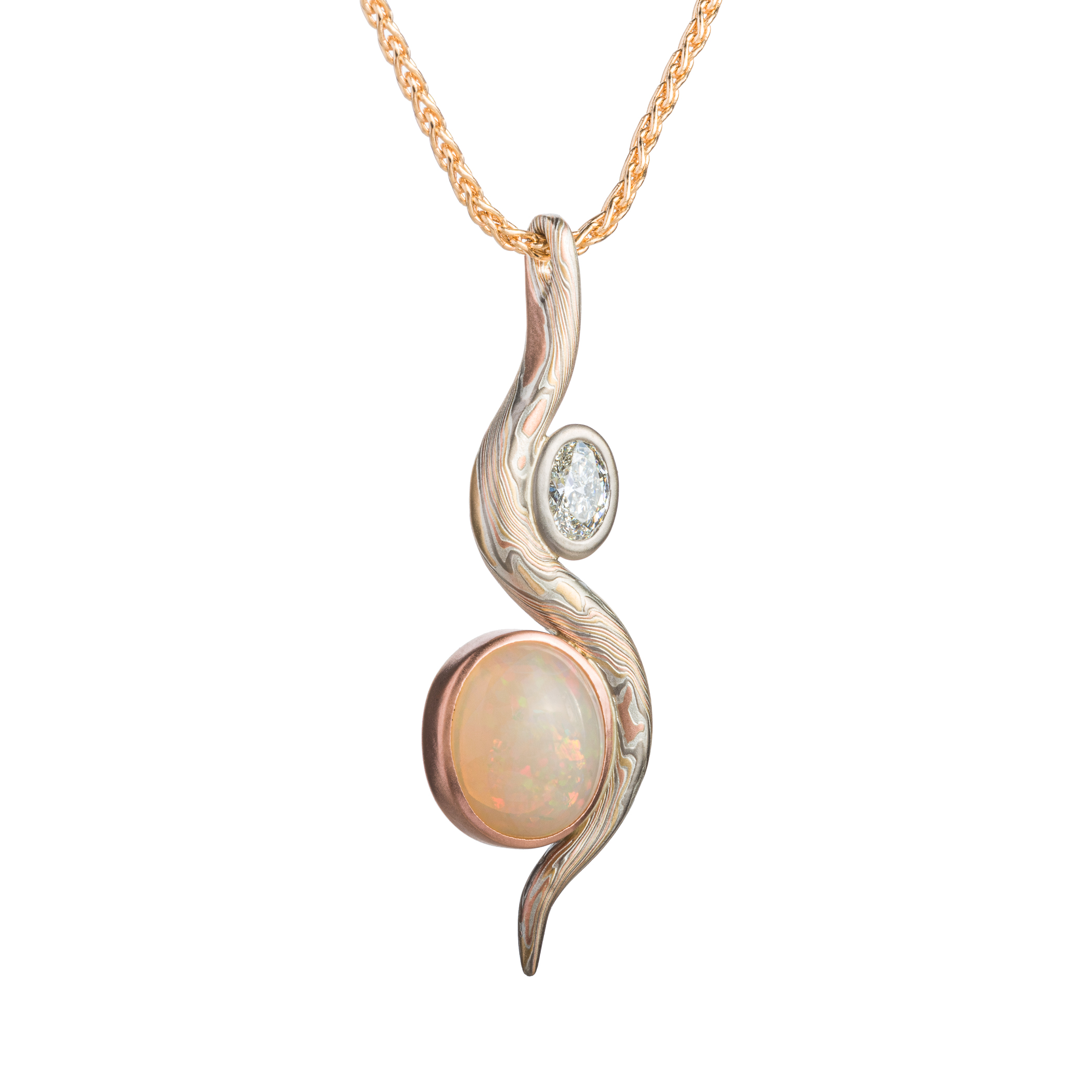 Elegant pendant made with a slender snake of patterned mokume gane gently curling around two oval shaped stones.