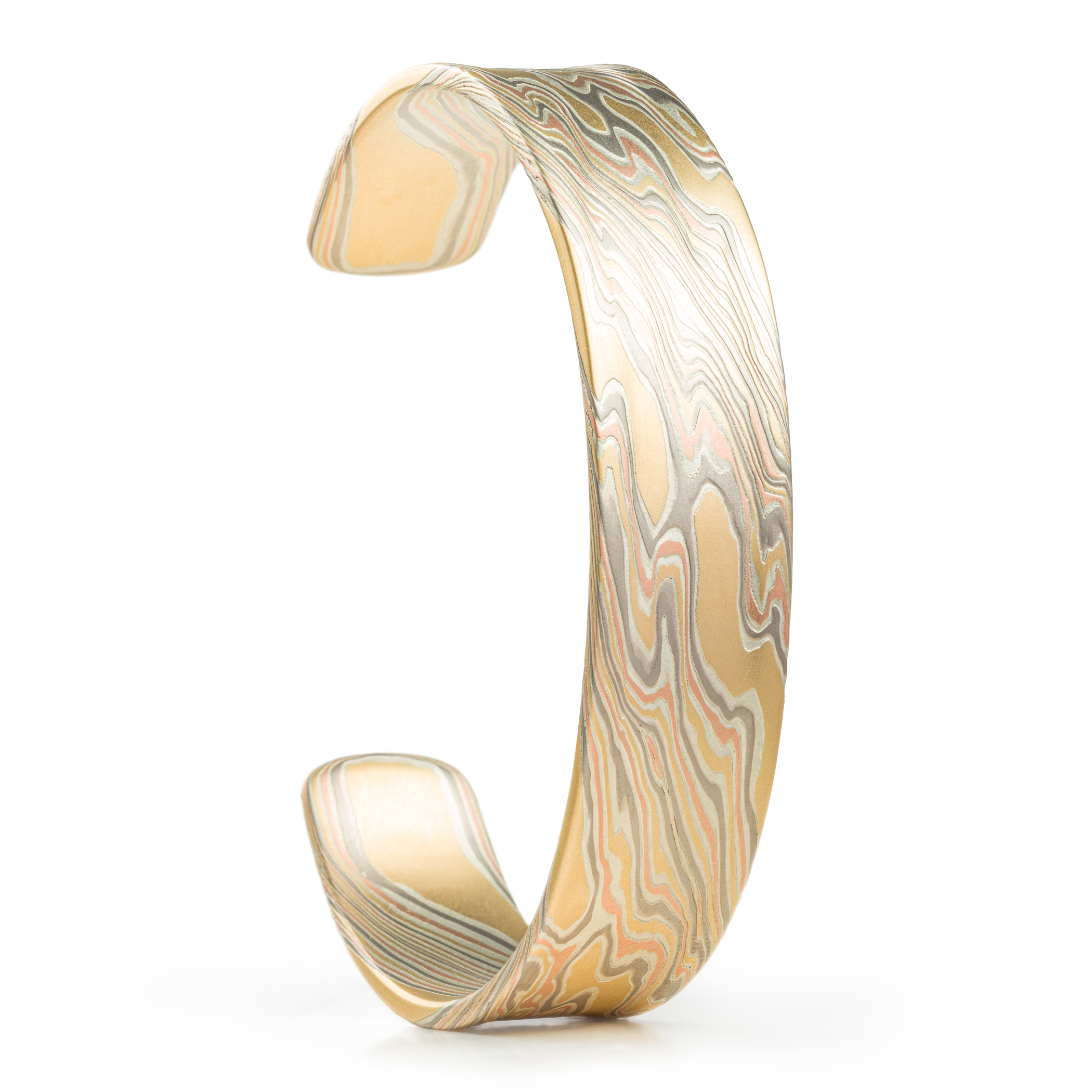 Mokume gane patterned mens bangle, wide, slightly textured, made with yellow gold, red gold, palladium and silver.