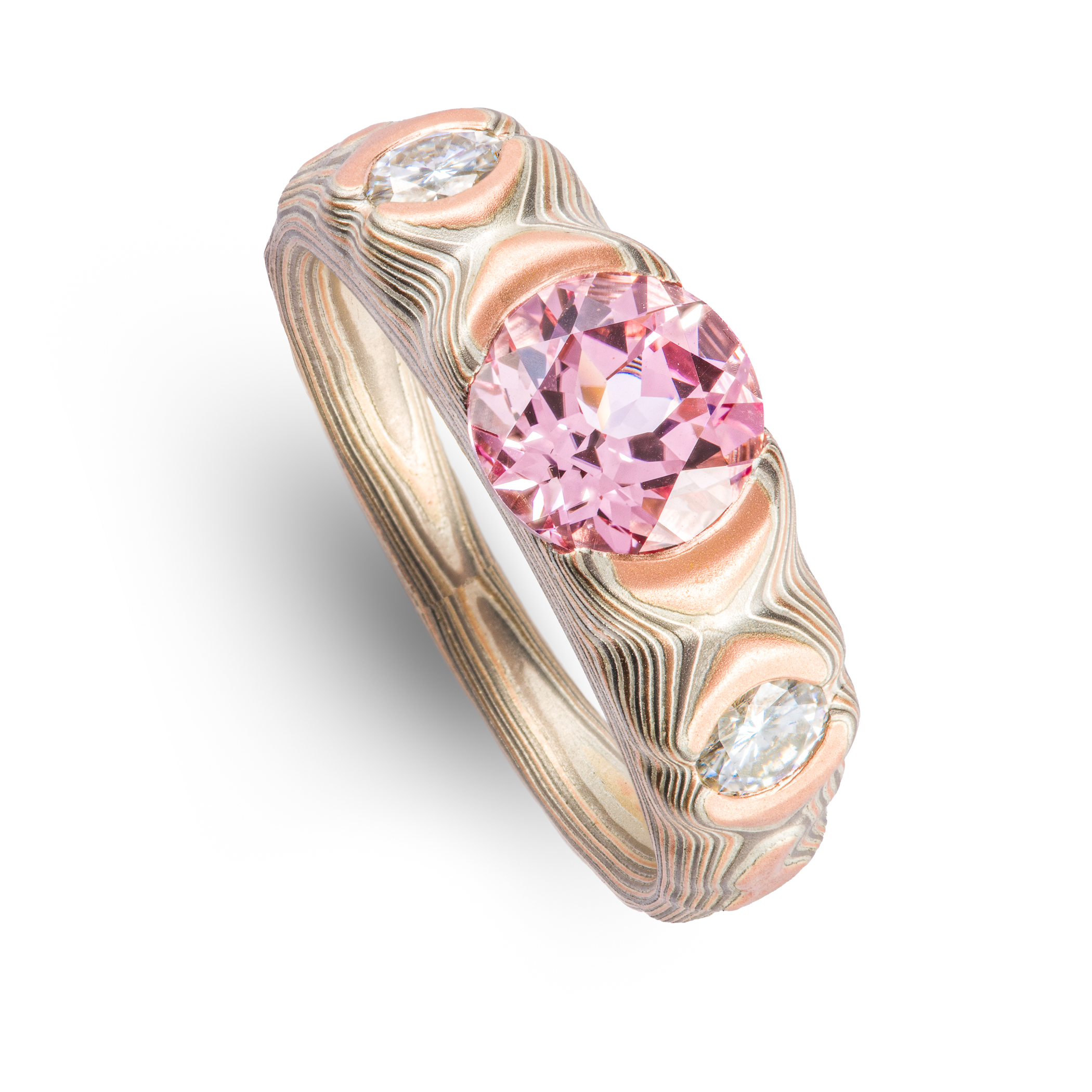 Tapered red gold, palladium and silver mokume gane patterned ring, cathedral style setting with a large pink stone, flanked on each side by a smaller white stone.