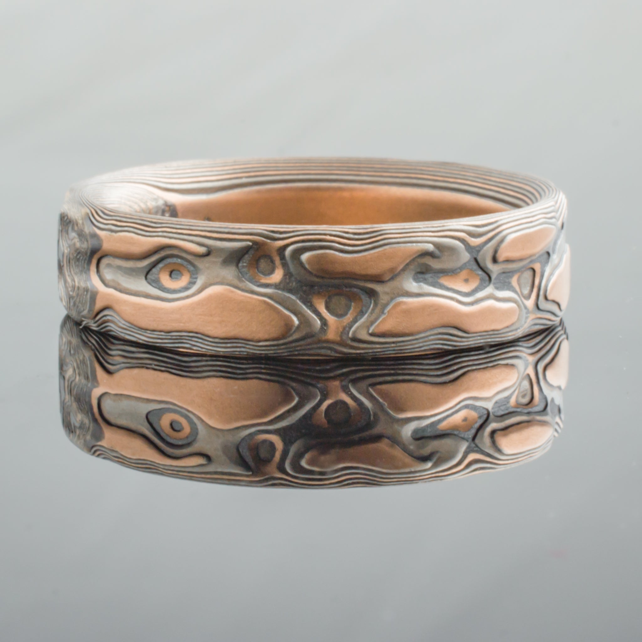 Arn Krebs mokume gane patterned ring, textured to look like red rocks, made with red gold, palladium and oxidized silver.