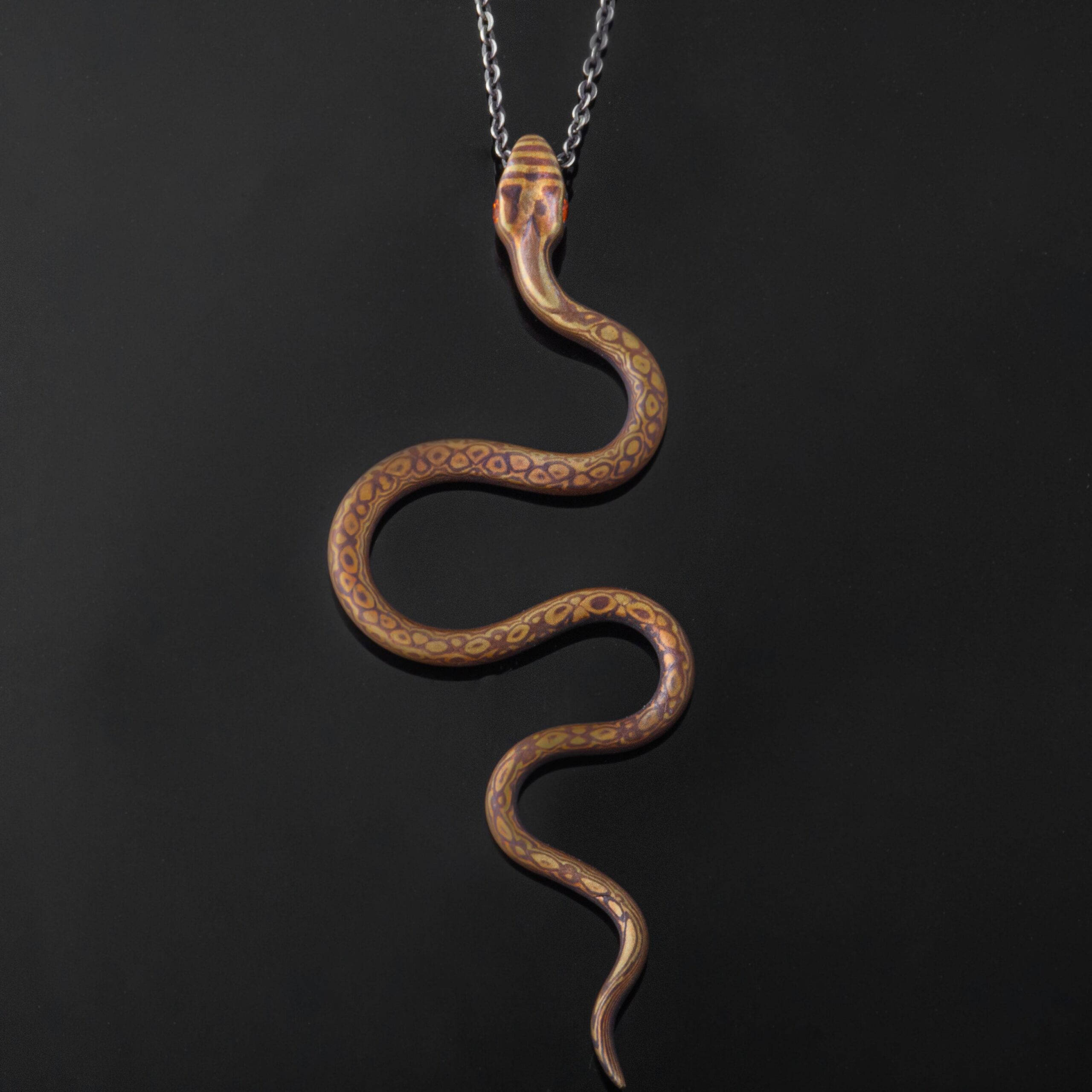 mokume gane snake shaped pendant, patterned to look like a tennessee coppherhead